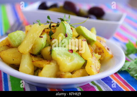 Gebratene Kartoffeln mit Zucchini in Olivenöl, mit eingelegtem Gemüse serviert. Hausmannskost. gesunde Ernährung Konzept Stockfoto