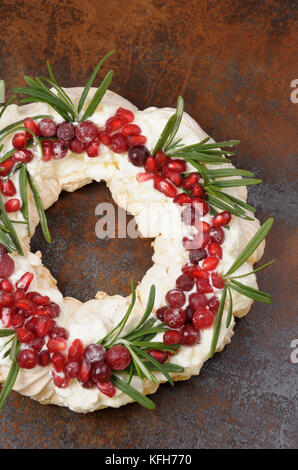 Weihnachten Kranz aus Baiser mit Sahne, Granatapfel, Cranberry, Rosmarin closeup Stockfoto