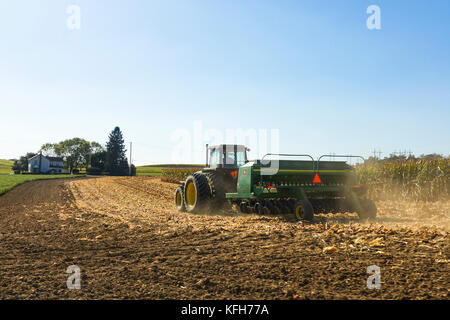 Bauer mit Traktor mit Bohrer Maschinen, arbeiten im Lande, Pennsylvania, United States. Stockfoto