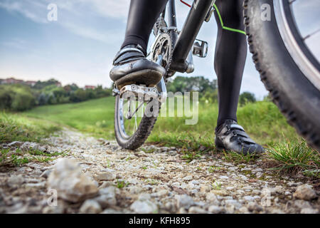 Unter einem Mountainbike auf einer Schotterstraße Stockfoto