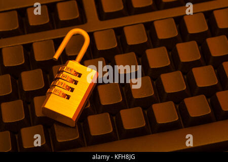 Kleines Kombinationsvorhängeschloss auf einer schwarzen, blanken Tastatur - für Cyber-Bedrohung/Sicherheit, Daten- und E-Mail-Sicherheit, E-Mail-Datenschutz. Und sicheres Login-Konzept. Stockfoto