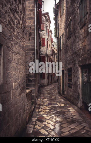 Mittelalterliche vintage Schmale Straße mit alten Steinstraßenbetoniermaschinen mit mittelalterlichen Gebäuden im alten europäischen Stadt Kotor in Montenegro Stockfoto