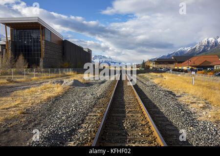 Canadian Pacific CP Railway Line Urban City Crossing Canmore Alberta Canada. Entfernte Landschaft Der Rocky Mountain Peaks, Skyline Des Banff National Park Stockfoto