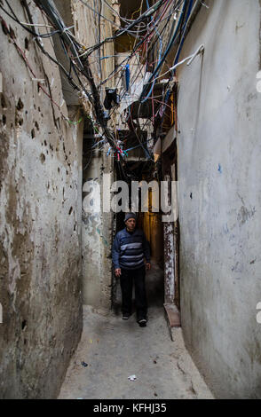 Beirut, Libanon. März 2016. Ein alter Mann, der durch das Tunnelnetz in Shatila ging. An der Wand ereigneten sich im Lager Anzeichen von Schüssen, die während mehrerer Unruhen entstanden waren. Über seinem Kopf verlaufen elektrische Drähte und Wasserrohre zusammen und bedrohen das Leben derjenigen, der unten ist. Der Libanon beherbergt über eine Million Flüchtlinge, die aus dem Nachbarland geflohen waren, um Sicherheit zu suchen. In den Flüchtlingslagern stehen sie vor Problemen wie täglichen Schikanen, häuslicher Gewalt, mangelnder Sanitär- und Bildungsbedarf, Nahrungsmittel- und Wasserknappheit sowie Wohnproblemen. (Kreditbild: © Susanna D'Aliesio/SOPA Via Stockfoto