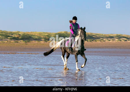 Southport, Merseyside, UK. 29. Oktober 2017. UK Wetter: Ein schöner sonniger Start in den Tag wie Yvonne Allen canters Ihr 7 Jahre altes Pferd "Trev' durch die Flut auf den goldenen Sandstrand von Southport Strand in Merseyside. Credit: cernan Elias/Alamy leben Nachrichten Stockfoto