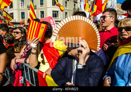 Barcelona, Katalonien, Spanien. Oktober 2017. Eine Frau mit dem traditionellen spanischen Fan beschützt sich vor der Sonne, während sie auf die Passage der Demonstration zur Verteidigung der Einheit Spaniens wartet. Zwei Tage nachdem die katalanische Regierung die Unabhängigkeit Kataloniens beschlossen hatte, und nach Angaben der Organisatoren, der katalanischen Zivilgesellschaft, sind mehr als eine Million Menschen auf die Straßen Barcelonas gekommen, um die Einheit Spaniens zu verteidigen. Die nächsten Tage werden für die spanische Politik von entscheidender Bedeutung sein. Nach der Erklärung der spanischen Regierung, Wahlen in Katalonien zu erzwingen, sind dies Wahlen Stockfoto