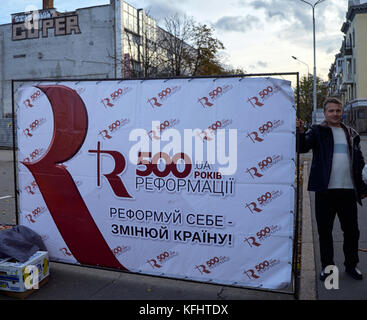 Kryvyi Rih, Ukraine. 29. Oktober, 2017. Mann neben Plakat auf der Straße an der Veranstaltung zum 500jährigen Jubiläum der Reformation Credit: dmytro aliokhin/alamy leben Nachrichten Stockfoto