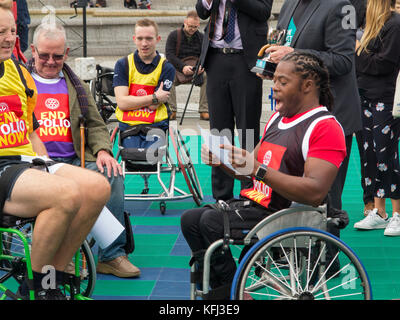 British MP's & Britischer Rollstuhl Basketball Spieler spielen Rollstuhlbasketball auf dem Trafalgar Square, der Sensibilisierung der Welt Polio Tag. Stockfoto