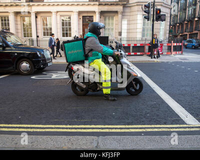 Eine Deliveroo rider liefert einige Essen zum Mitnehmen auf einem Moped Stockfoto