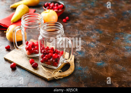 Zwei Gläsern für die Herstellung von einem heißen Getränk mit Preiselbeeren und Äpfel Stockfoto