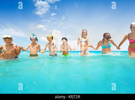 Große Gruppe von Freunden diverse kinder Jungen und Mädchen, die im Wasser halb unter Wasser in Scuba gear glücklich