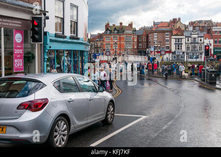 Autos und Fußgänger warten auf die Drehbrücke über Whitby Hafen zu öffnen. Stockfoto