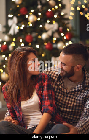 Mädchen und Freund Uhren mit lieben einander in Heiligabend Stockfoto