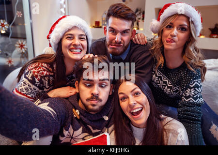 Junge fröhliche Freunde lustiges Gesicht in Silvester Stockfoto