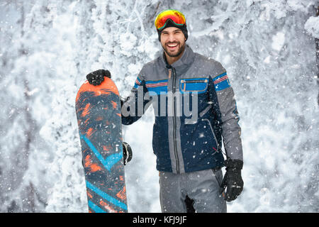 Portrait von glücklichen männlichen Snowboarder auf dem Berg Stockfoto