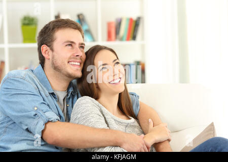 Glückliches Paar träumen oben sitzen auf einem Sofa im Wohnzimmer zu Hause suchen Stockfoto