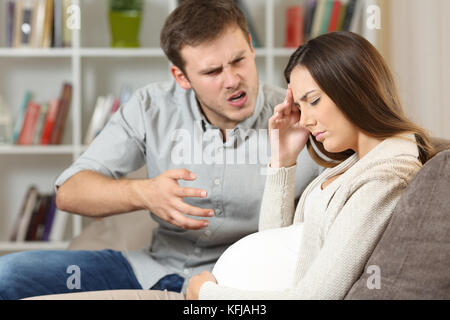 Traurig schwangere Frau mit ihrem Ehemann auf einem Sofa zu Hause sitzen kämpfen Stockfoto