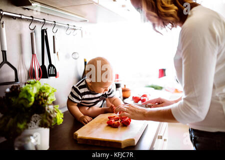 Junge Mutter mit Baby Boy, Hausarbeit. Stockfoto