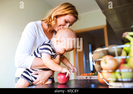 Junge Mutter mit Baby Boy, Hausarbeit. Stockfoto