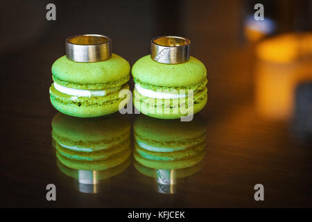 Trauringe mit Brillanten auf Macarons Stockfoto