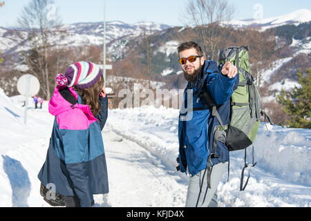 Paar Wanderer erkunden schneebedeckten Berge an einem sonnigen Tag Stockfoto