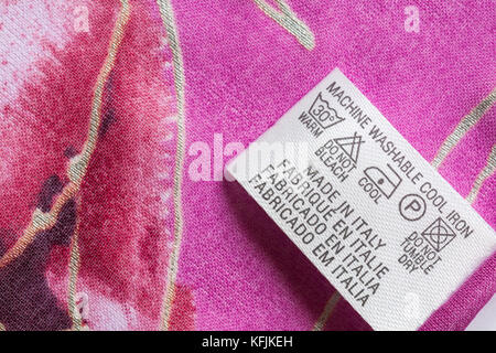Etikett in rosa Schal der Frau in Italien mit Sorgfalt waschen Symbole gemacht - in Großbritannien Großbritannien Großbritannien Stockfoto
