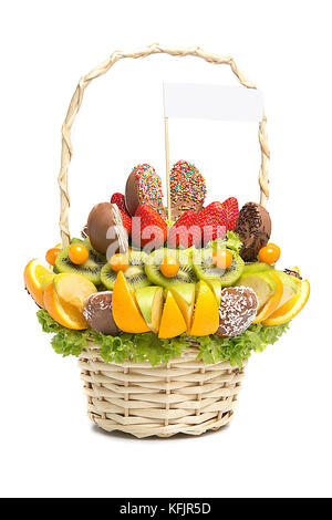 Korb mit Früchten und Beeren in der Schokolade auf weißem Hintergrund. Handgefertigte. Erdbeeren und Zitrusfrüchte, Äpfel, Kiwi. Geschenkkorb mit Obst und Süßigkeiten. Stockfoto