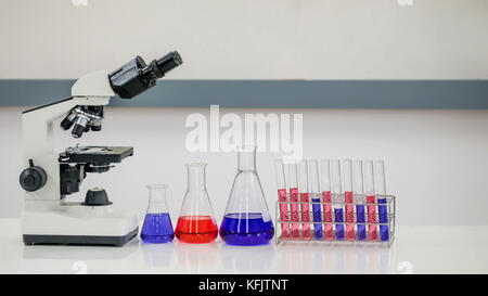 Forschung im Labor, Flasche mit chemischen Flüssigkeit mit Mikroskop Stockfoto