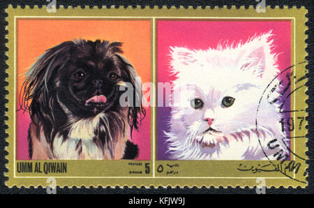 Eine Briefmarke in Umm al qiwain gedruckt zeigt Katze und Hund ab Serie: unterschiedliche Rassen von Hunden und Katzen, ca. 1971 Stockfoto