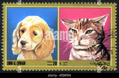 Eine Briefmarke in Umm al qiwain gedruckt zeigt Katze und Hund ab Serie: unterschiedliche Rassen von Hunden und Katzen, ca. 1971 Stockfoto