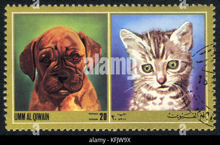 Eine Briefmarke in Umm al qiwain gedruckt zeigt Katze und Hund ab Serie: unterschiedliche Rassen von Hunden und Katzen, ca. 1971 Stockfoto