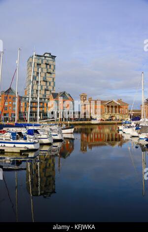 Boote, Mehrfamilienhäuser und Reflexionen in Ipswich Marina an einem hellen Herbstnachmittag. Stockfoto