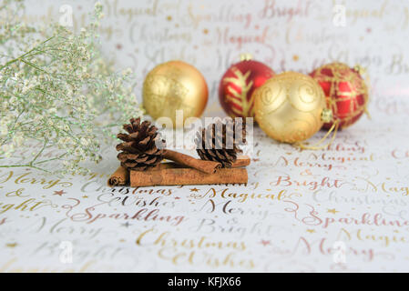 Helle weihnachten Fotografie Bild mit rot gold Glitzern Xmas Tree Spielereien mit glitter Blumen und Tannenzapfen auf Nahrung spice Cinnamon Sticks Stockfoto