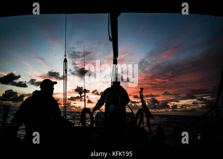 Segler auf einer Yacht bei Sonnenuntergang über der Nordsee Stockfoto