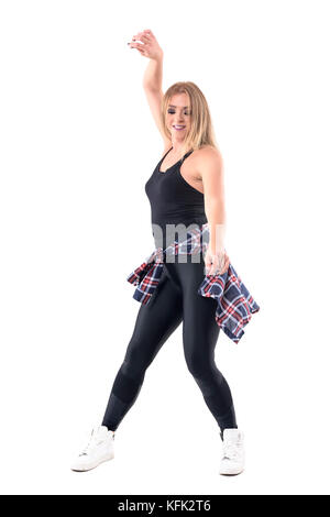 Bewegung der weiblichen Jazz Dance oder Dancehall Tänzer schwingen die Arme lächelnd und blickte nach unten. volle Gehäuselänge Portrait auf weißem Hintergrund. Stockfoto