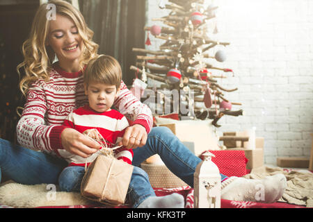 Portrait der glücklichen Mutter und Sohn auf dem Hintergrund der Weihnachtsbaum im neuen Jahr Zimmer. Die Idee für Postkarten Stockfoto