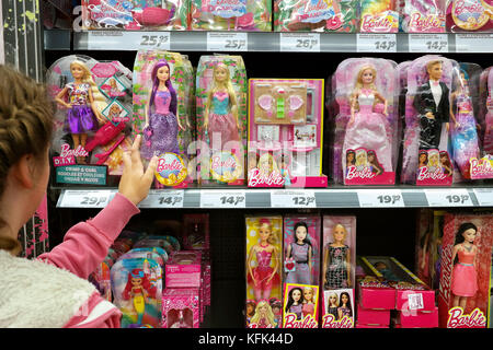 Ein junges Mädchen kauft Barbie-Puppen in einem Spielwarenladen ein Stockfoto