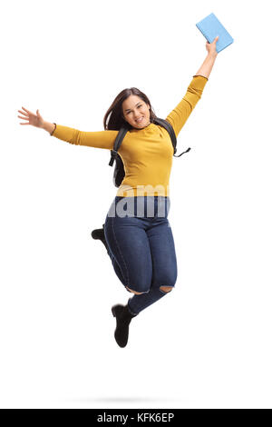 Überglücklich Studentin mit einem Rucksack und einem Buch springen und gestikulierend Glück auf weißem Hintergrund Stockfoto