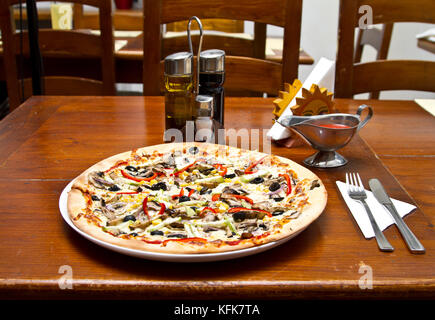 Vegetarische Pizza auf einen hölzernen Tisch im Restaurant Stockfoto