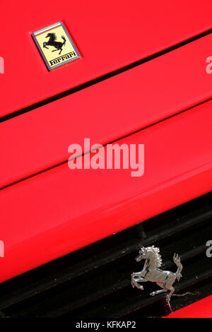 Ferrari-Abzeichen und stolzendes Pferdeemblem auf der Motorhaube des Sportwagens. Stockfoto