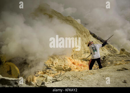 Ein bergmann Auszüge Schwefel Felsen von der Kawah Ijen Vulkan, Ostjava, Indonesien. Stockfoto