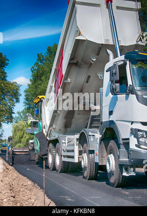 Asphalt fertiger Maschine beim Straßenbau, Verkehrswegebau crew gelten die erste Schicht von Asphalt Stockfoto