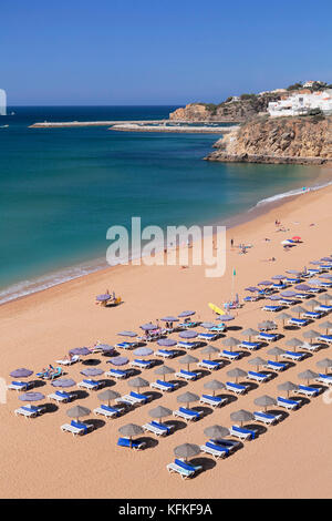 Sonnenschirme und Sonnenliegen am Strand Praia do Peneco Strand, Albufeira, Algarve, Portugal Stockfoto