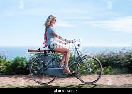 Los Angeles, Ca - 11. Juli: Frau reitet ein Fahrrad auf einem Pfad mit Blick auf den Ozean in Los Angeles, Kalifornien am 30. März 2011. Stockfoto