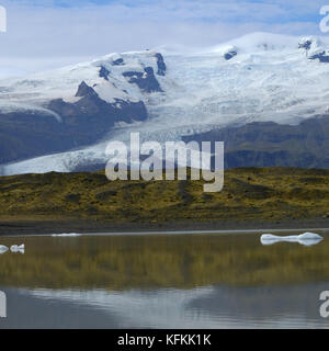 Fjallsarlon Eisberg Lagune und Vatnajokull Gletscherzunge Gletscherblick mit Spiegelung der Berge auf dem Wasser im See, Südisland Stockfoto