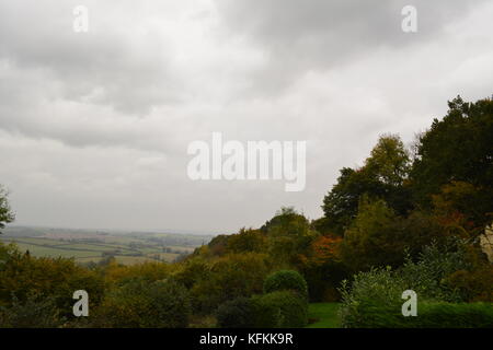 Blick vom Hügel über Bäume und Büsche in Richtung Felder und offene Landschaft mit bedeckt grau und trübe Himmel in South herefordshire England Großbritannien Stockfoto