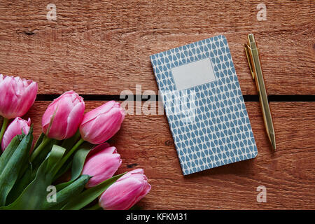 Ein Bündel von rosa Tulpen schreiben in einem notebook Frühling Atmosphäre Stockfoto