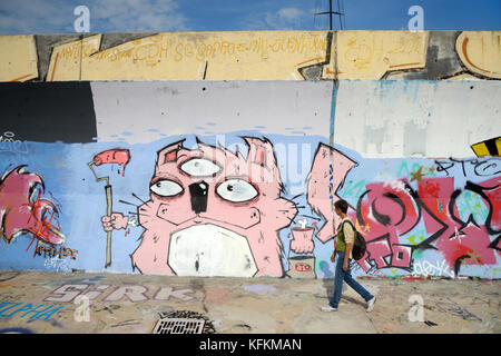 Frau mit Back Pack vorbei gehen. Graffiti-Covered Sea Wall in La Ciotat, Provence Frankreich Stockfoto