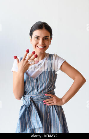 Frau mit Himbeeren auf den Fingern Stockfoto