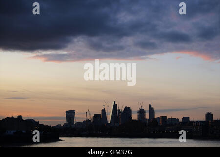 London, Großbritannien. 30.. Oktober 2017. Der atemberaubende Sonnenuntergang über der City of London erleuchtet die ikonischen Gebäude, die kürzlich in London entstanden sind, und die riesige Anzahl von Turmdrehkräne, die noch mehr Wolkenkratzer erschaffen. Das Foto wurde vom Flussufer an der Canary Wharf aufgenommen. Kredit: Nigel Bowles/Alamy Live Nachrichten Stockfoto